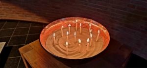 340421022_521919206797423_6064204006692412911_n Eine Schale mit Sand, in dem Kerzen stecken.